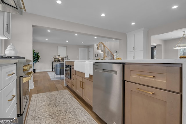kitchen featuring appliances with stainless steel finishes, light hardwood / wood-style flooring, and white cabinets