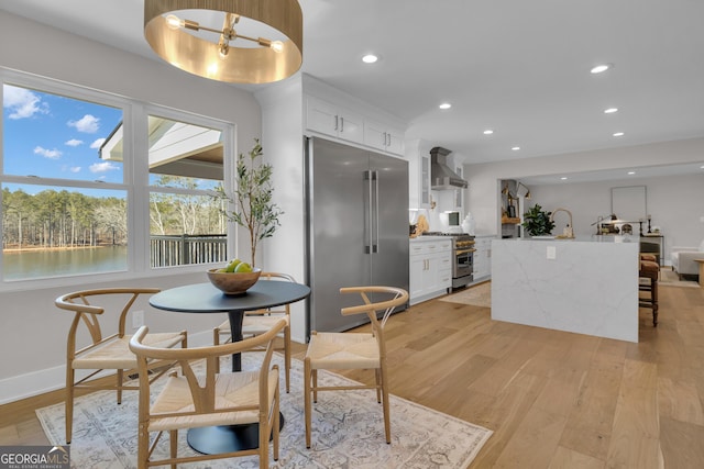 dining area featuring a water view and light wood-type flooring