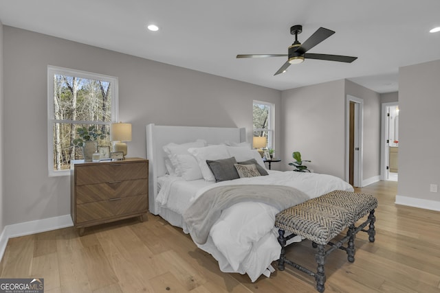 bedroom featuring ceiling fan, multiple windows, and light hardwood / wood-style flooring
