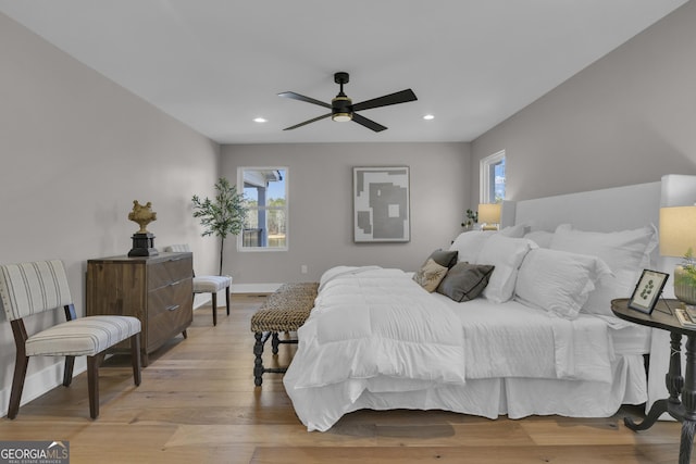 bedroom with multiple windows, ceiling fan, and light hardwood / wood-style floors