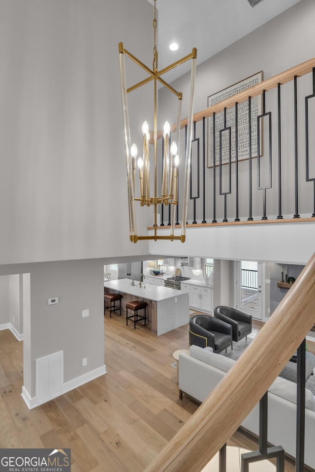 staircase featuring an inviting chandelier and hardwood / wood-style flooring