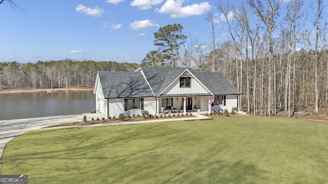 modern inspired farmhouse featuring a garage, a front yard, a porch, and a water view
