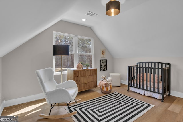 bedroom with vaulted ceiling and light hardwood / wood-style floors