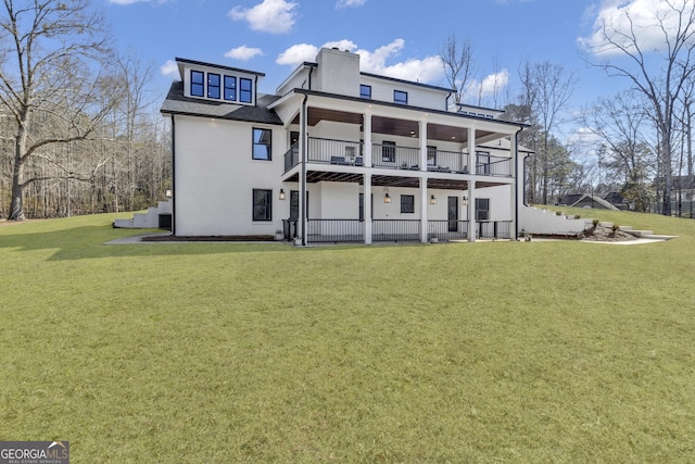 back of house with a lawn and a balcony