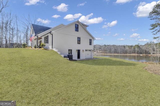view of side of property featuring a garage, a water view, central air condition unit, and a lawn