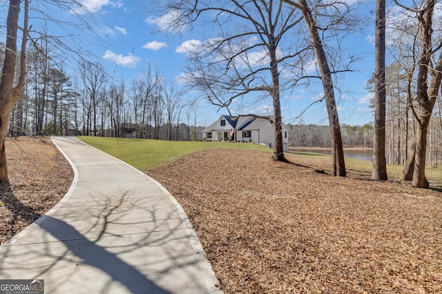 surrounding community featuring a water view and a lawn