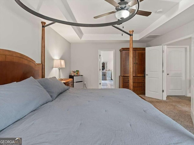 carpeted bedroom featuring a raised ceiling and ceiling fan