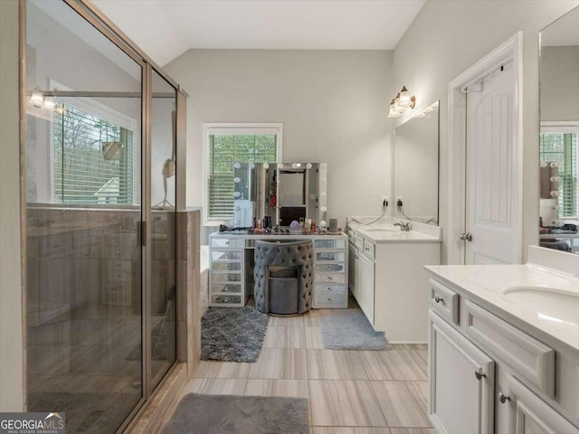 bathroom featuring vaulted ceiling, a shower with door, and a healthy amount of sunlight