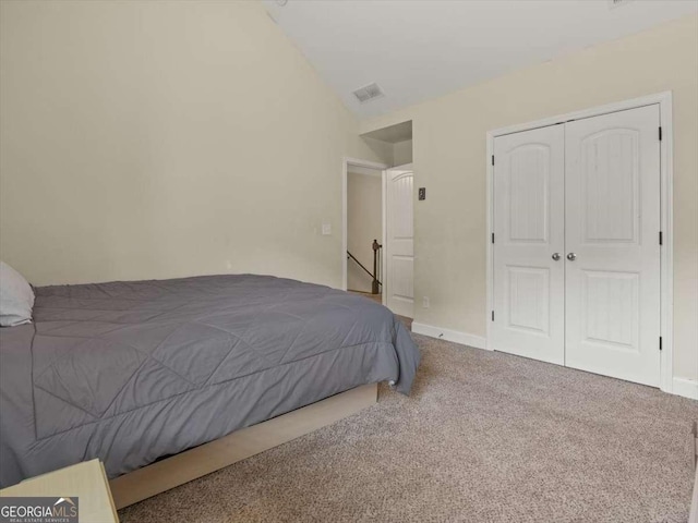 bedroom with lofted ceiling, a closet, and carpet