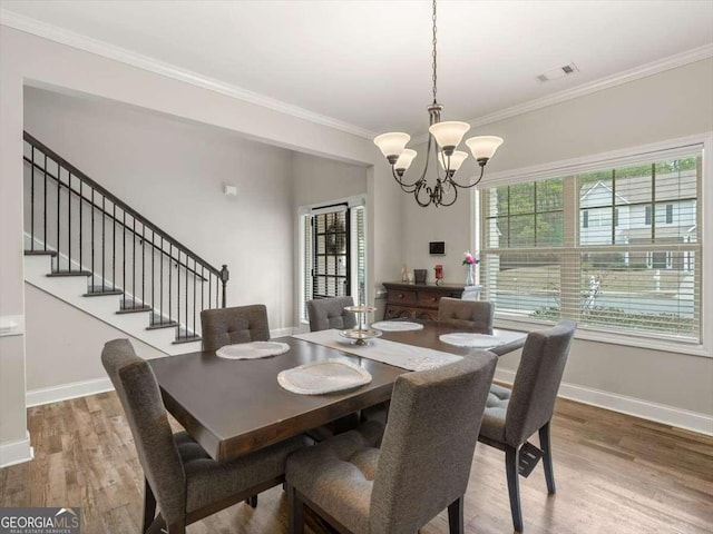 dining room featuring hardwood / wood-style flooring, crown molding, and a chandelier