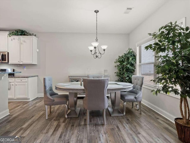 dining area featuring dark wood-type flooring and a chandelier