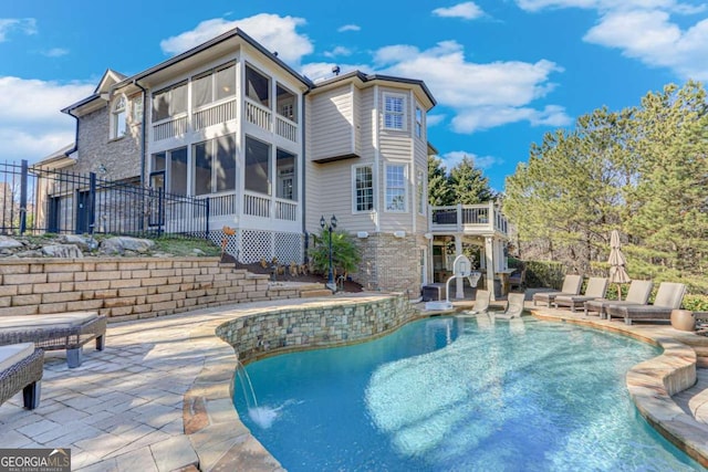 view of pool featuring a sunroom, a patio, and pool water feature