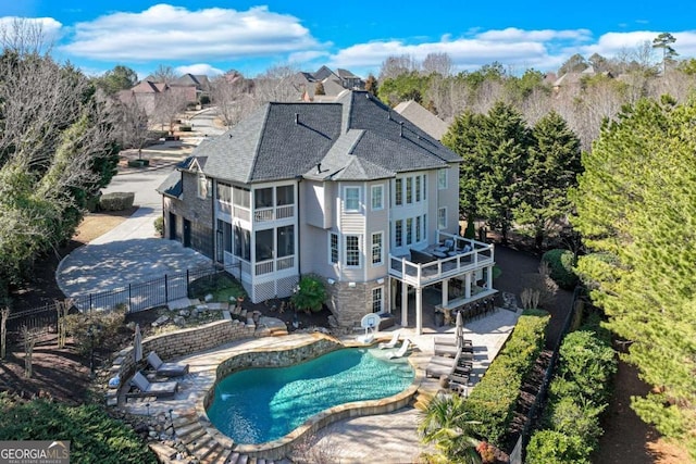 exterior space with a fenced in pool, a sunroom, and a patio