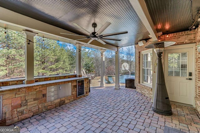 view of patio / terrace featuring ceiling fan and exterior kitchen