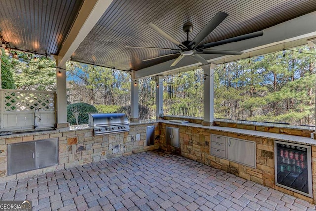 view of patio featuring sink, area for grilling, grilling area, ceiling fan, and beverage cooler