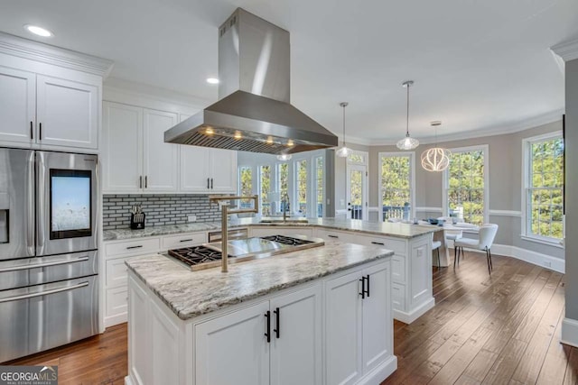 kitchen with a kitchen island, island range hood, decorative light fixtures, kitchen peninsula, and stainless steel appliances