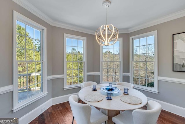 dining space featuring wood-type flooring, ornamental molding, and a notable chandelier