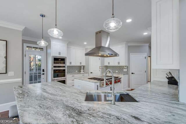 kitchen with hanging light fixtures, stainless steel appliances, sink, and island exhaust hood