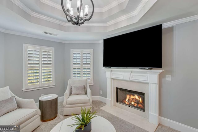 living room with an inviting chandelier, light colored carpet, a tray ceiling, and crown molding