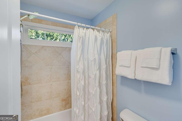 bathroom featuring toilet and shower / bath combo