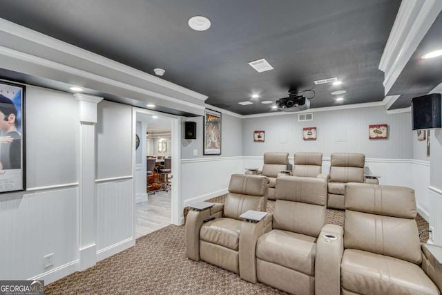 home theater room featuring crown molding and light colored carpet