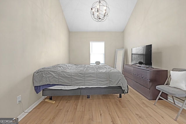 bedroom with lofted ceiling, a chandelier, and light hardwood / wood-style floors