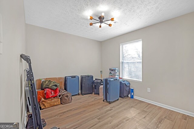 clothes washing area with cabinets, stacked washer / drying machine, and light wood-type flooring