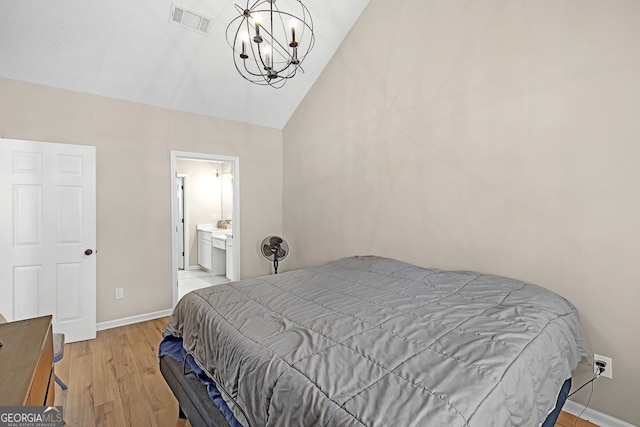 bedroom with a notable chandelier, light hardwood / wood-style flooring, and lofted ceiling