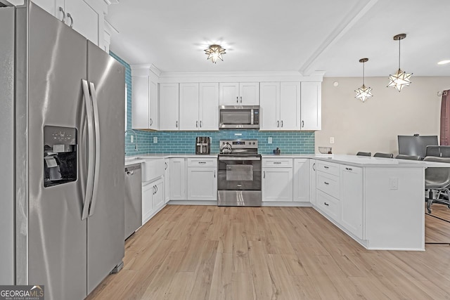 kitchen featuring appliances with stainless steel finishes, backsplash, white cabinetry, pendant lighting, and kitchen peninsula