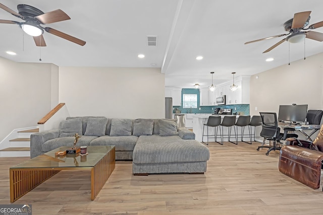 living room featuring ceiling fan and light hardwood / wood-style floors