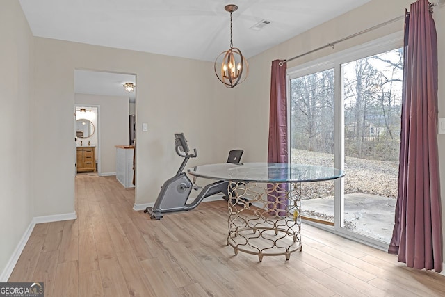 dining area with light wood-type flooring and a chandelier