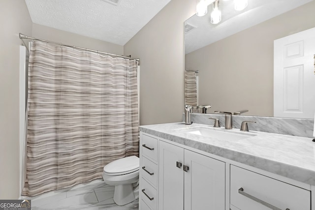 bathroom with vanity, toilet, and a textured ceiling