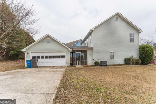 view of front of house featuring central AC unit, a garage, and a front yard