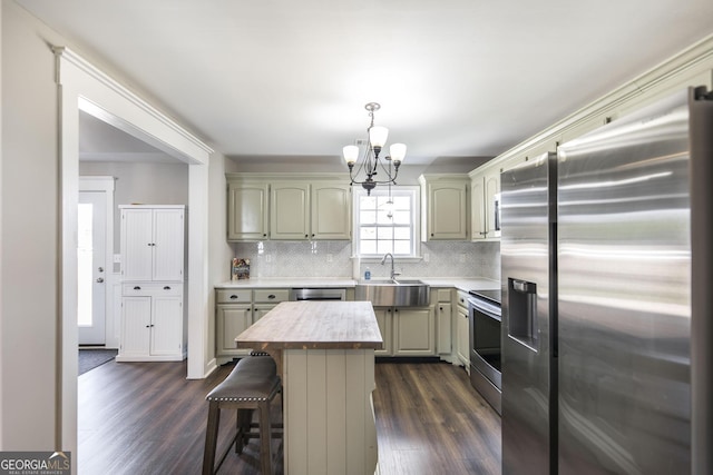 kitchen featuring sink, stainless steel appliances, a center island, a kitchen bar, and dark hardwood / wood-style flooring