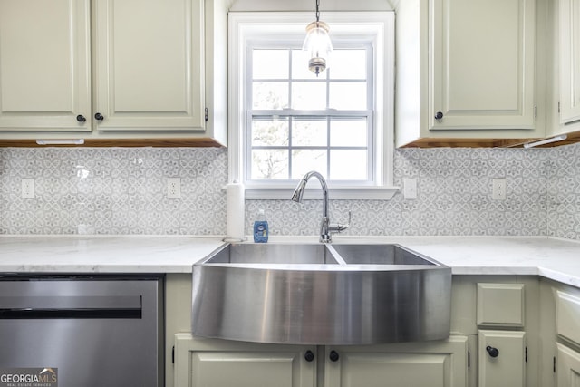 kitchen with pendant lighting, light stone countertops, sink, and tasteful backsplash