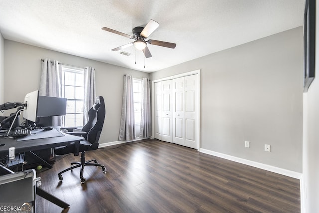 home office featuring dark wood-type flooring, ceiling fan, and a textured ceiling