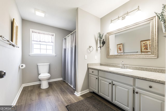 bathroom with vanity, toilet, and wood-type flooring