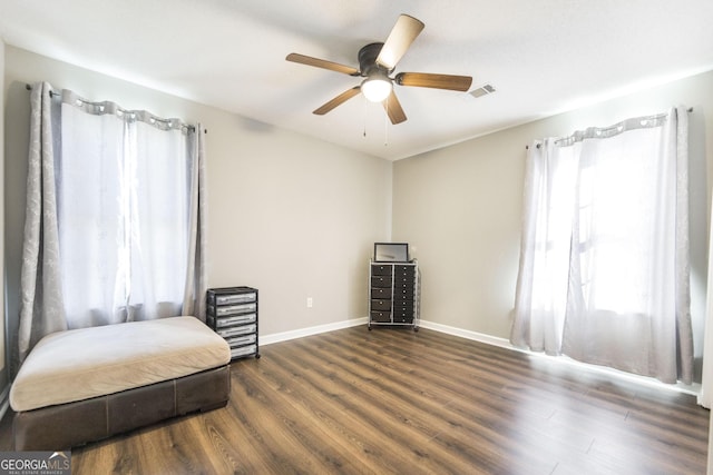 living area with dark wood-type flooring and ceiling fan