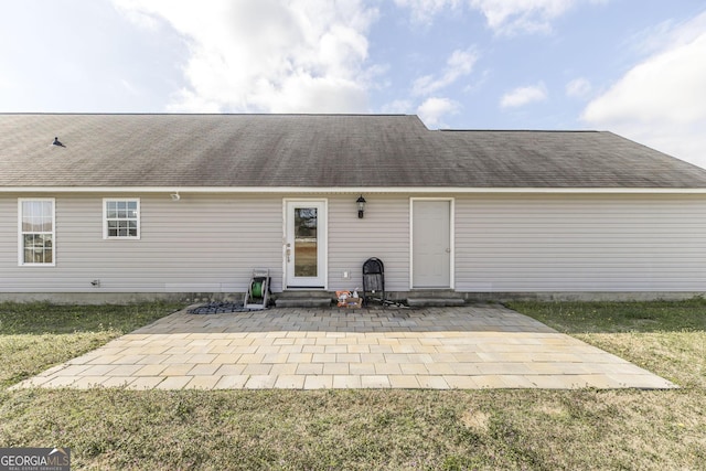 rear view of house featuring a yard and a patio