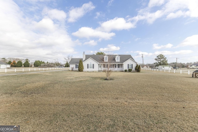 cape cod home featuring a front lawn and a rural view