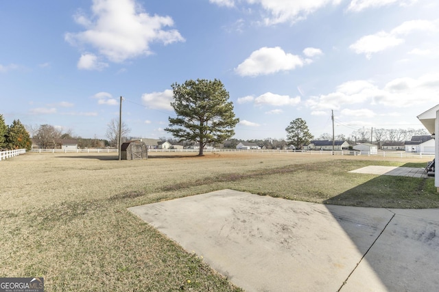 view of yard with a storage shed and a patio