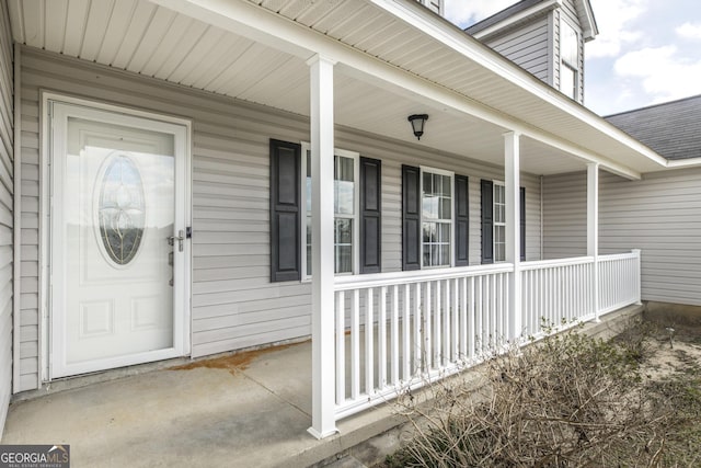 view of exterior entry featuring covered porch