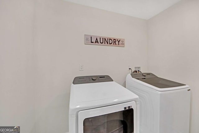 clothes washing area with washer and clothes dryer