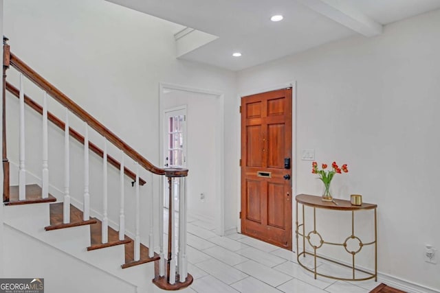 entrance foyer featuring beamed ceiling