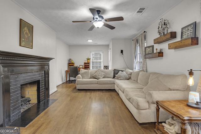 living room with ornamental molding, hardwood / wood-style floors, a textured ceiling, and ceiling fan