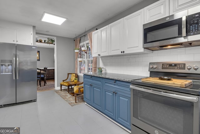 kitchen featuring white cabinetry, decorative backsplash, blue cabinets, and appliances with stainless steel finishes