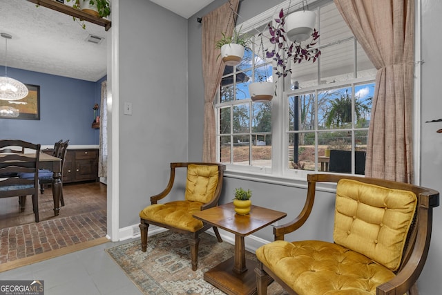 living area with a textured ceiling and an inviting chandelier