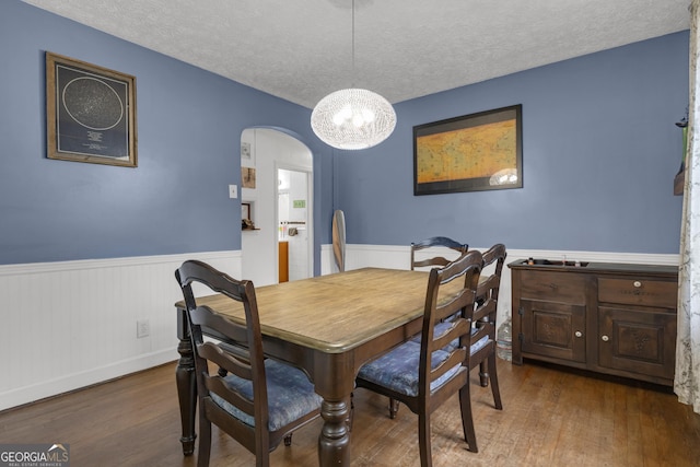 dining room featuring dark wood-type flooring and a textured ceiling