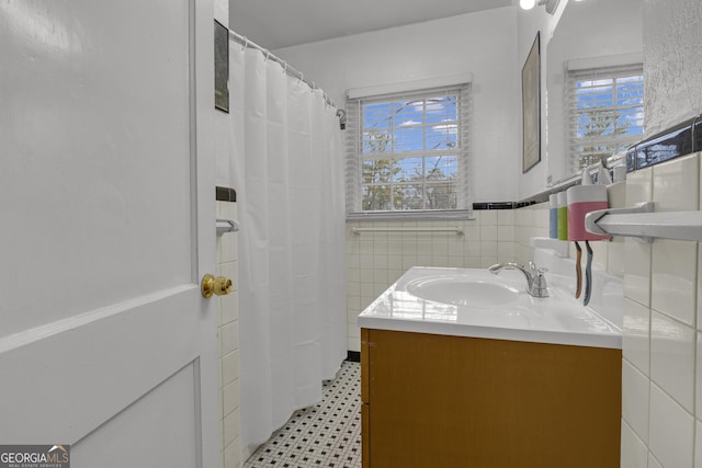 bathroom featuring a shower with curtain, vanity, tile walls, and a wealth of natural light