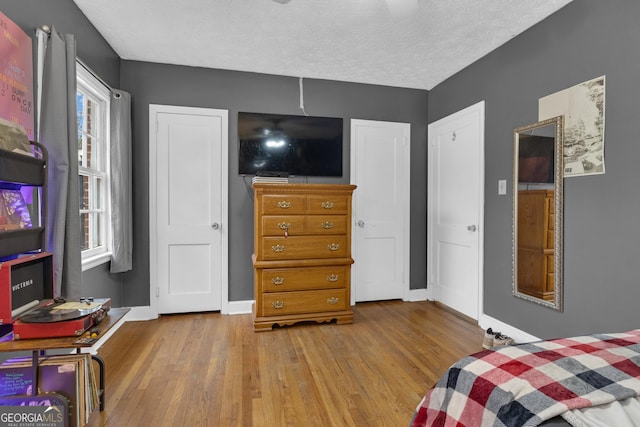 bedroom with light hardwood / wood-style flooring and a textured ceiling